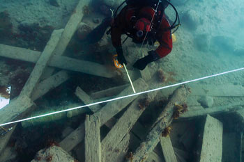 Un Archéologue de Parcs Canada mesurant la position d’un canon en utilisant une ligne de référence sur lesite HMS Erebus dans le « champ de débris » près de la coque de l'épave.